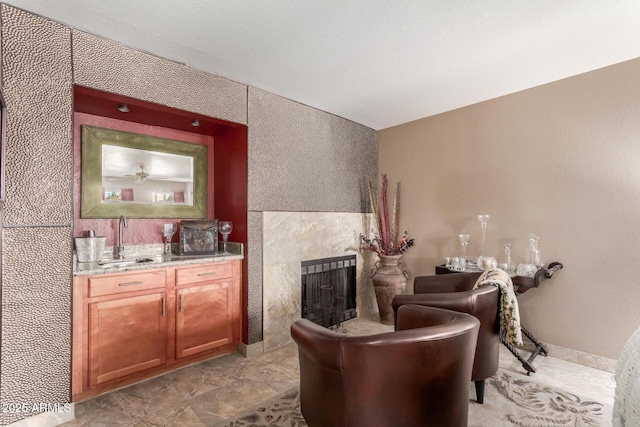 sitting room featuring a tile fireplace and indoor wet bar