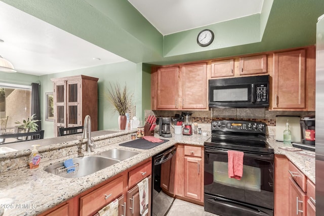 kitchen with sink, black appliances, and light stone countertops