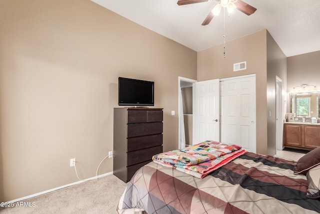 carpeted bedroom with lofted ceiling, ensuite bathroom, and ceiling fan