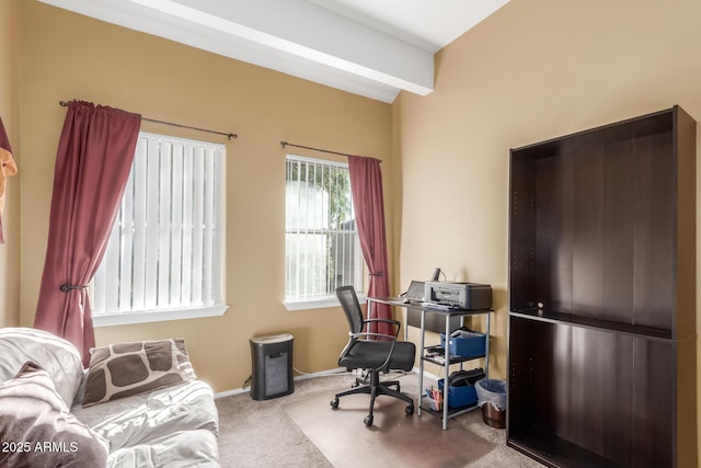 carpeted home office featuring beam ceiling