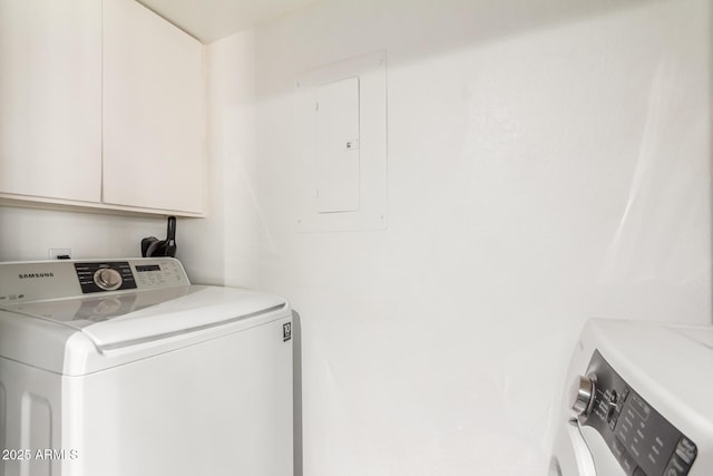 laundry room featuring electric panel, cabinets, and washer / clothes dryer