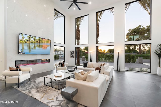 interior space featuring a towering ceiling, a healthy amount of sunlight, and ceiling fan