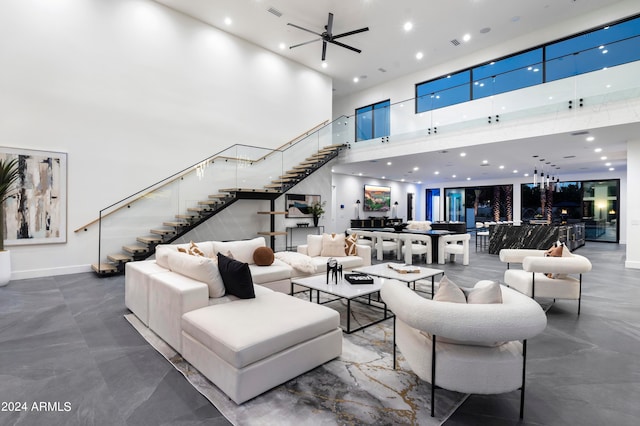 living room featuring ceiling fan and a towering ceiling