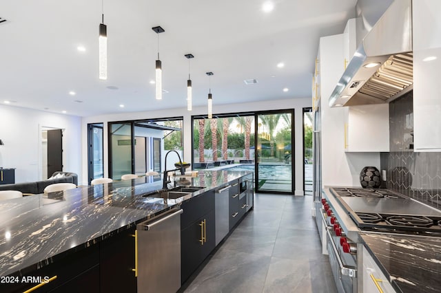 kitchen with sink, backsplash, stainless steel appliances, pendant lighting, and white cabinets