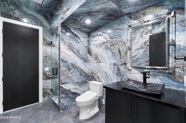 bathroom featuring vanity, tile walls, a shower with shower door, and toilet