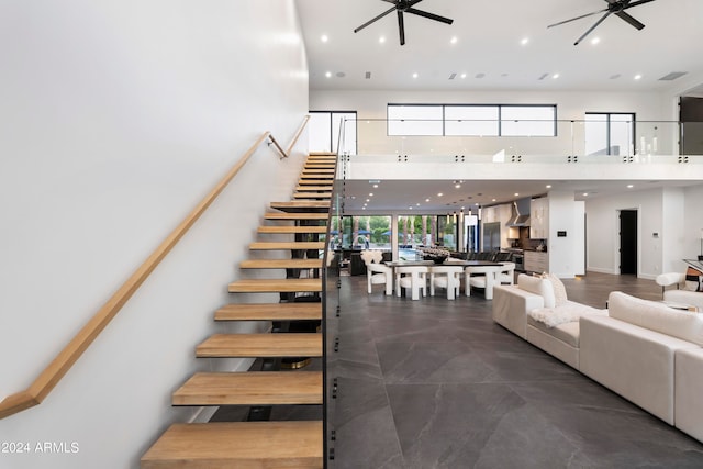 staircase featuring ceiling fan