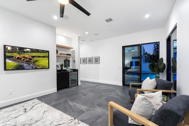 living room with ceiling fan, bar, and beverage cooler