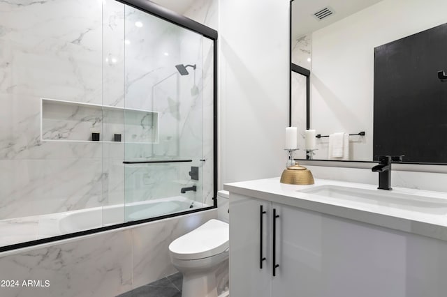 full bathroom featuring vanity, combined bath / shower with glass door, toilet, and tile patterned floors