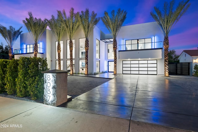 view of front of home featuring a balcony and a garage