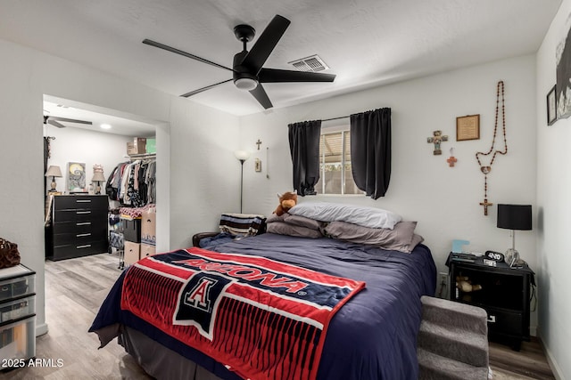 11132 W Indiana Ave, Youngtown, AZ 85363 - bedroom featuring light wood-style floors, a ceiling fan, a spacious closet, and a closet