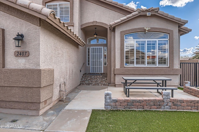 view of exterior entry with a patio area