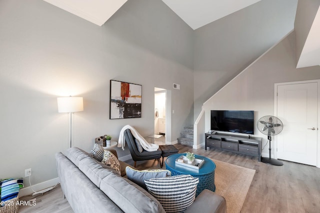 living room with a high ceiling and light hardwood / wood-style flooring