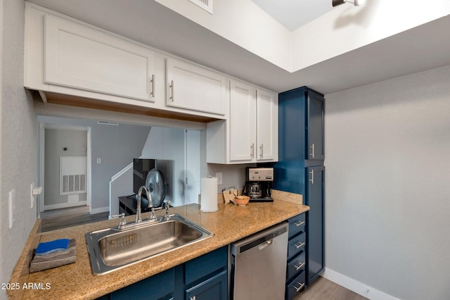 kitchen with white cabinets, dishwasher, blue cabinets, and sink