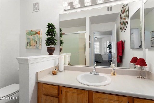 bathroom featuring vanity, toilet, and an enclosed shower