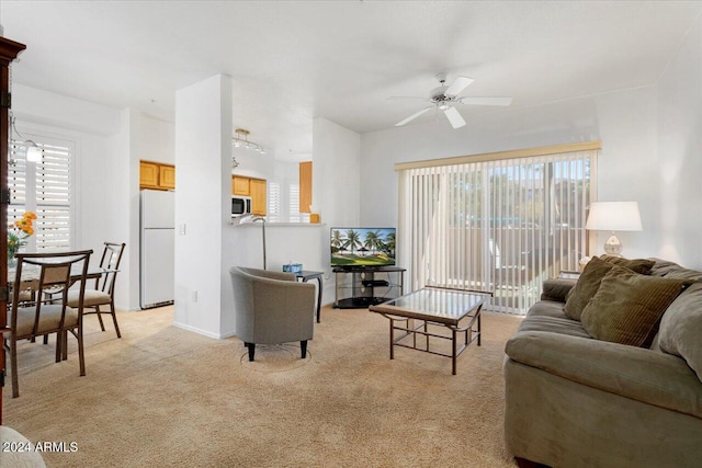 living room featuring a wealth of natural light, ceiling fan, and light colored carpet