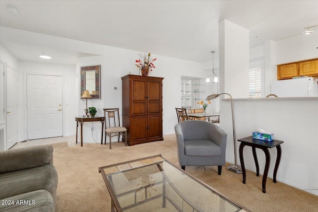 carpeted living room with a chandelier