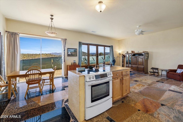 kitchen featuring white range with electric cooktop, a center island, visible vents, pendant lighting, and a ceiling fan