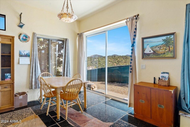 dining area with granite finish floor, a mountain view, and plenty of natural light