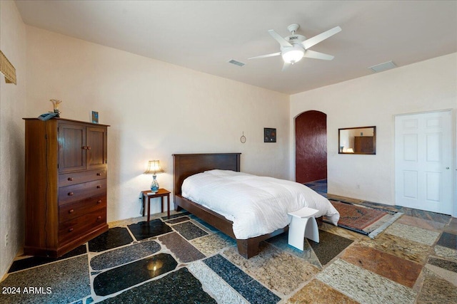 bedroom with visible vents, arched walkways, and ceiling fan