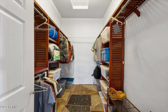 spacious closet featuring stone finish flooring