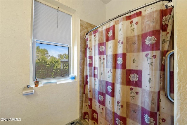 bathroom featuring a shower with curtain and a textured wall