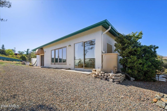 back of property featuring stucco siding
