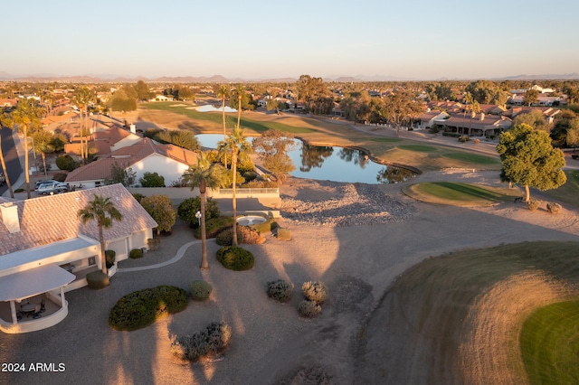 aerial view at dusk featuring a water view