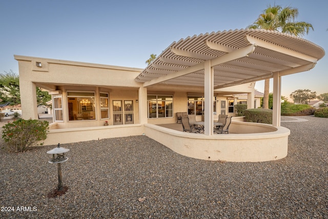 back of property with a pergola and a patio