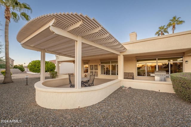 rear view of house with a pergola, exterior kitchen, and a patio