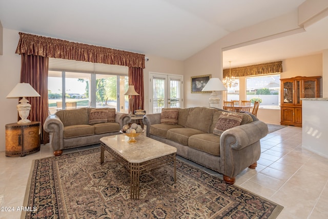 living room with a chandelier, light tile patterned floors, and lofted ceiling