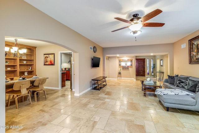 living room featuring ceiling fan with notable chandelier