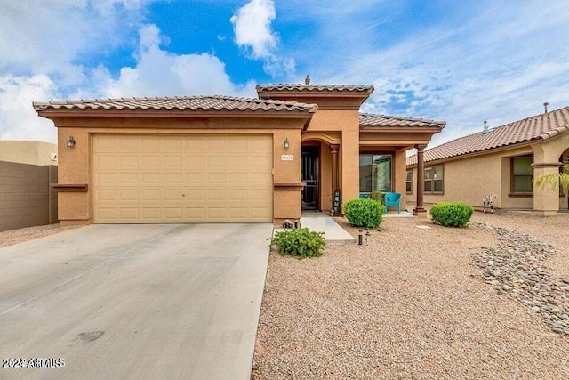 mediterranean / spanish-style home with a garage, concrete driveway, and stucco siding