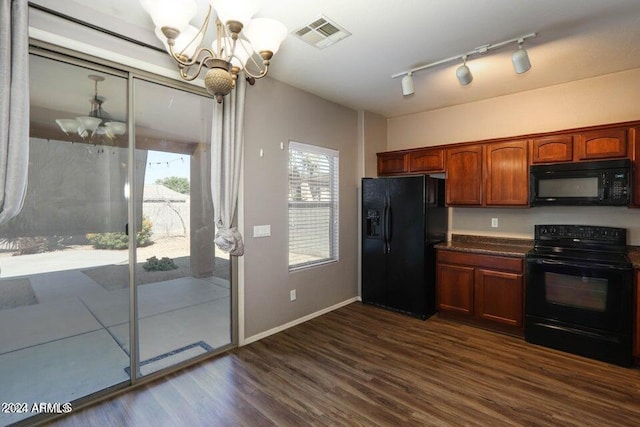 kitchen featuring visible vents, dark countertops, dark wood-type flooring, black appliances, and a notable chandelier