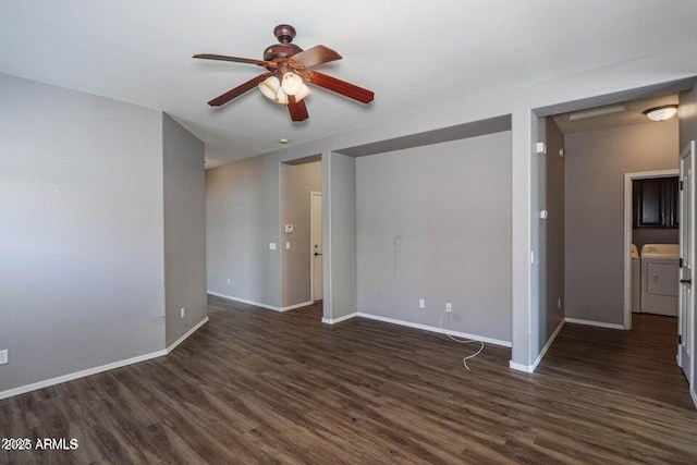 empty room with dark wood-style floors, ceiling fan, baseboards, and washer and clothes dryer