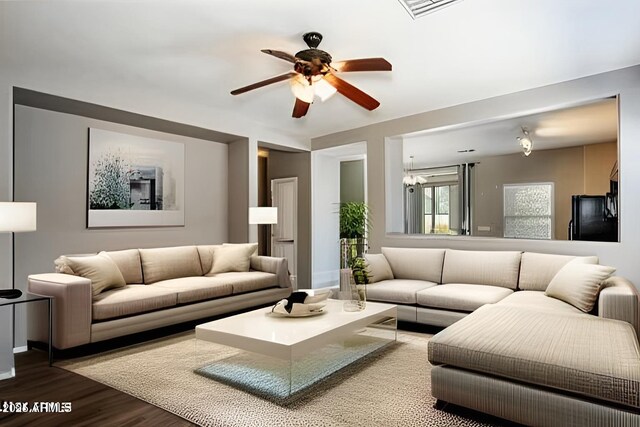 living area with ceiling fan with notable chandelier, visible vents, and wood finished floors
