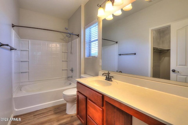 bathroom featuring wood finished floors, shower / washtub combination, vanity, and toilet