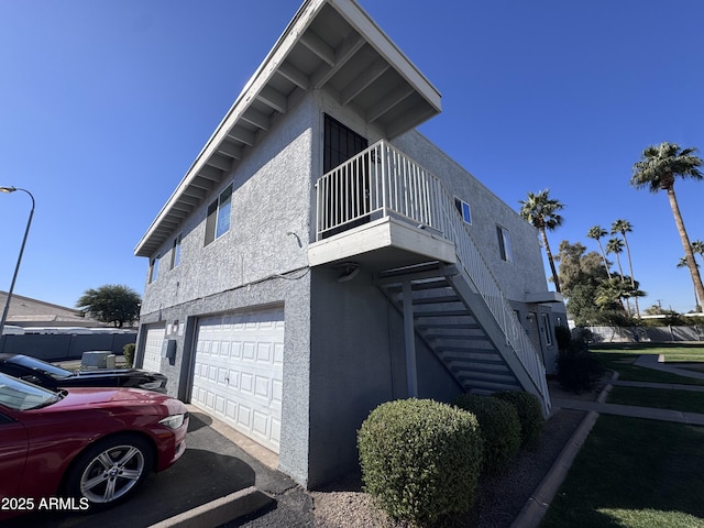 view of side of property featuring a balcony and a garage