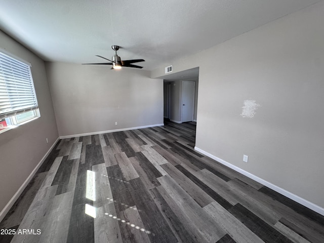 empty room featuring ceiling fan and dark wood-type flooring