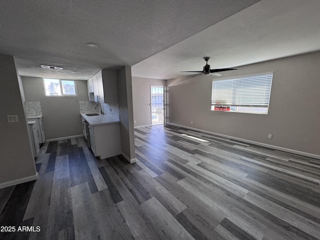 kitchen with white cabinets, a textured ceiling, dark hardwood / wood-style floors, and sink