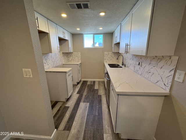 kitchen featuring decorative backsplash, a textured ceiling, sink, white cabinets, and dark hardwood / wood-style floors