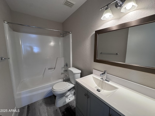 full bathroom featuring hardwood / wood-style floors, vanity, shower / bath combination, and toilet