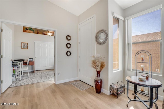 foyer with vaulted ceiling and light hardwood / wood-style flooring