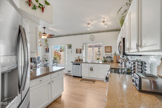 kitchen with decorative backsplash, sink, light hardwood / wood-style flooring, stainless steel appliances, and white cabinets