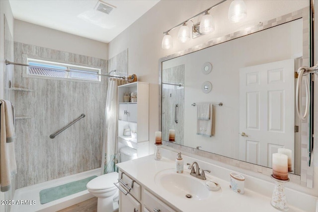 bathroom featuring toilet, vanity, and a shower with curtain