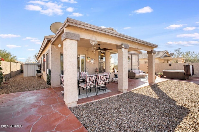 view of patio / terrace with ceiling fan, a hot tub, and an outdoor living space