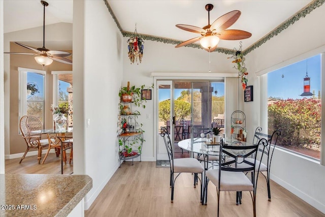 dining area with ceiling fan, lofted ceiling, and light hardwood / wood-style floors