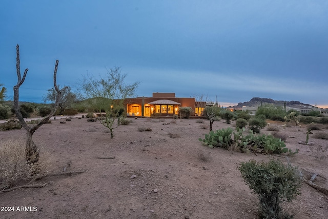 back of house at dusk featuring a mountain view