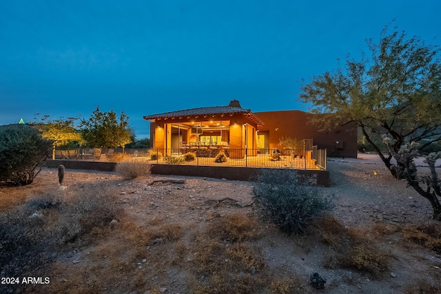 rear view of property with a chimney, a patio area, and fence