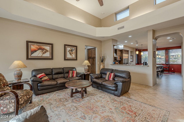 living room featuring light tile patterned floors, plenty of natural light, visible vents, and a ceiling fan