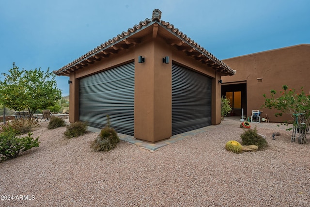 view of property exterior featuring a garage, driveway, and stucco siding